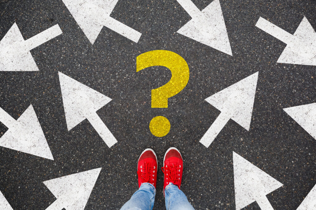 Person wearing read shoes in-front of a yellow question mark, surrounded by arrows