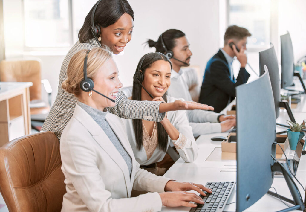Call center, training and group of women at computer in discussion at help desk with advice from team leader. Learning, planning and help, black woman mentor coaching staff in customer service agency.