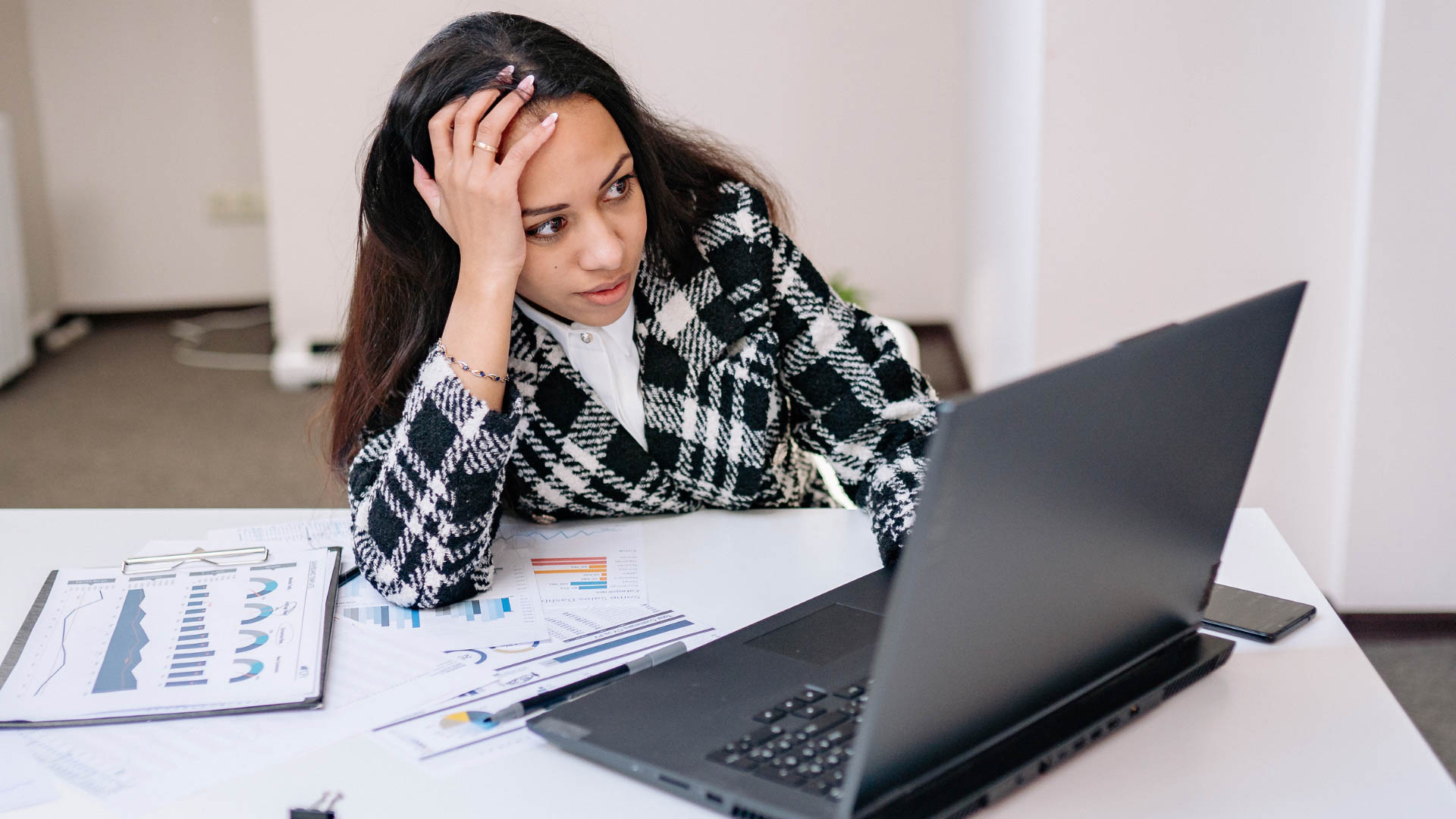 Person sitting at desk on laptop looking frustrated