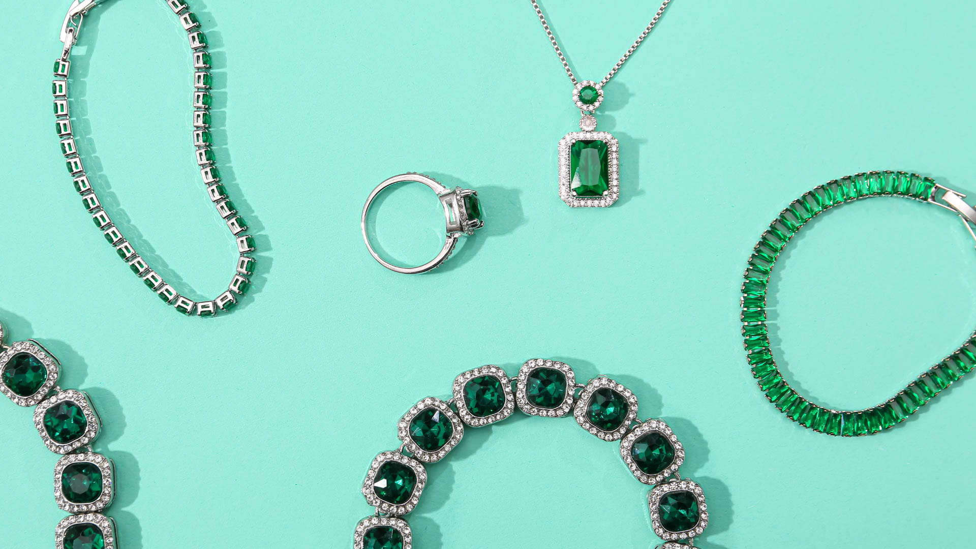 green tortoise jewelry laid out on surface same color surface