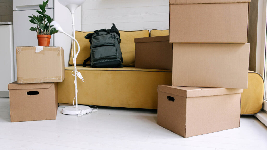 Stacked moving boxes and belongings in a room, symbolizing organization or reset.