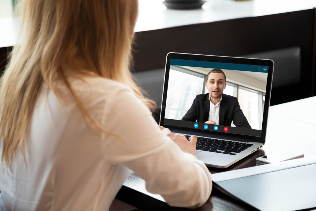 Two professionals collaborating over a laptop in an office setting.