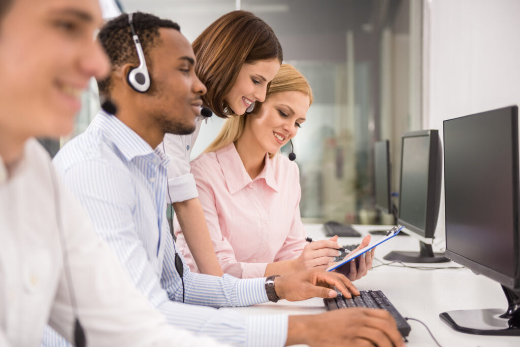 Group shot of employees working at a desk of a call center